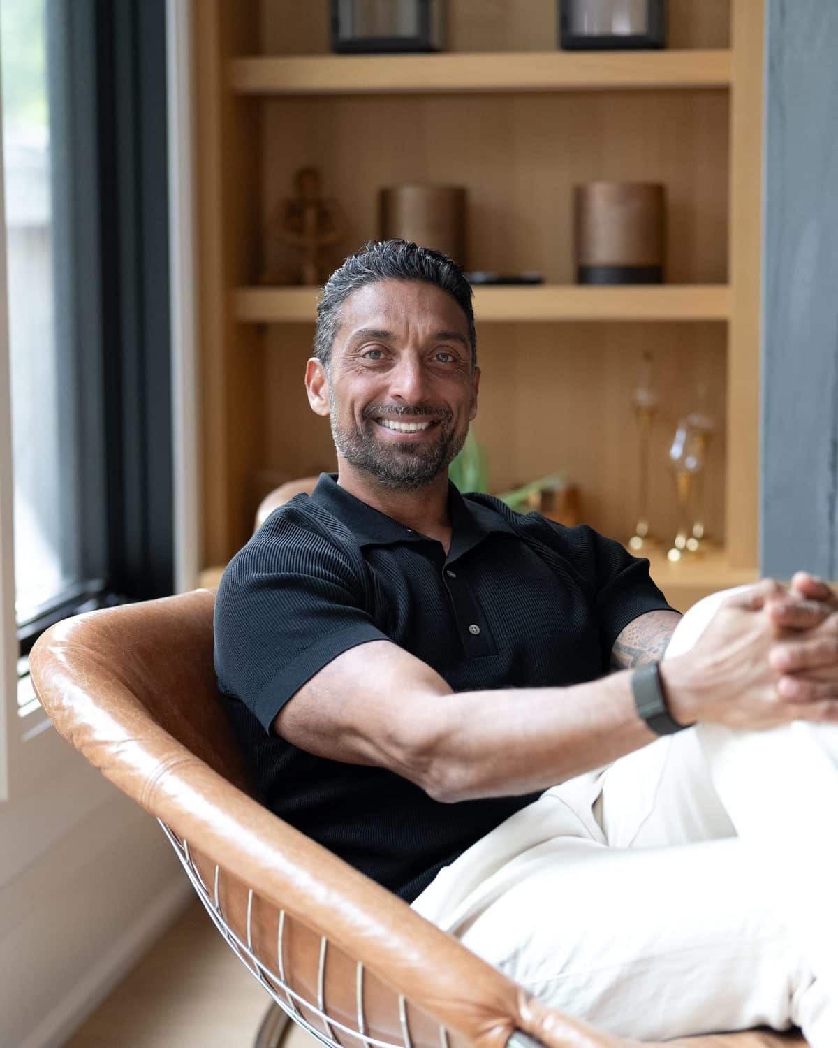Zarak Fatah smiling, seated in a leather chair at home